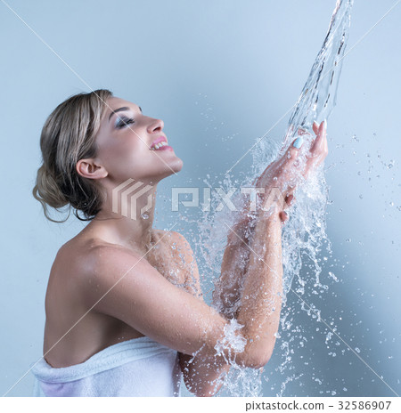 Happy girl catching water stream in her hands Happy girl catching water stream in her hands 32586907