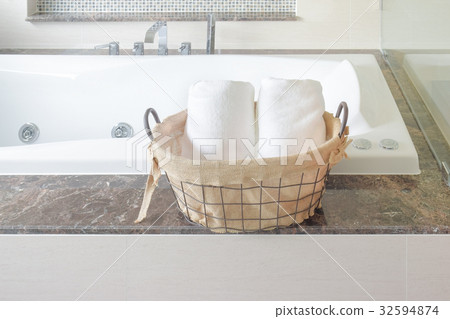 Towel in basket naxt to bathtub in the bathroom Towel in basket naxt to bathtub in the bathroom 32594874
