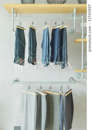 Skirt and jeans hanging in industrial style closet Skirt and jeans hanging in industrial style closet 32594897