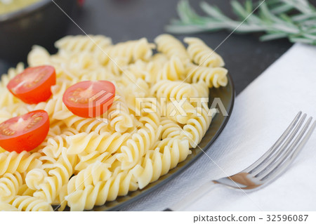 Italian pasta with tomatoes on the black plate 32596087