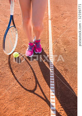 Female legs with tennis racket 32599771