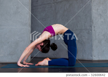 Skinny flexible female yogini bending backwards 32600642