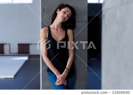 Smiling skinny female model standing at the wall 32600690