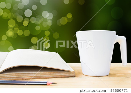 Notebook and white cup on wooden table 32600771