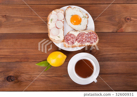 Sandwiches and tea on a wooden background. 32600931