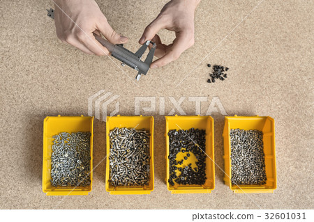 Plastic boxes with screws and male hands Plastic boxes with screws and male hands 32601031