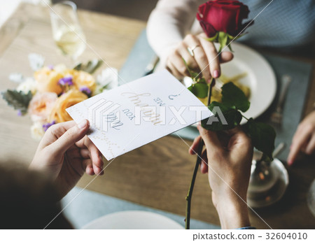 Romantic Man Giving Will You Marry Me Card with a Rose to Propose Woman 32604010