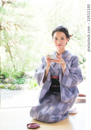 A woman in kimono drinking tea A woman in kimono drinking tea 32612180