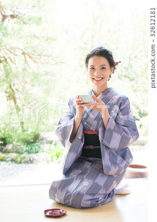 A woman in kimono drinking tea A woman in kimono drinking tea 32612181