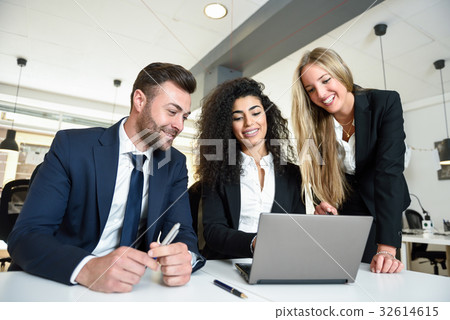 Multi-ethnic group of three businesspeople meeting in a modern o Multi-ethnic group of three businesspeople meeting in a modern o 32614615