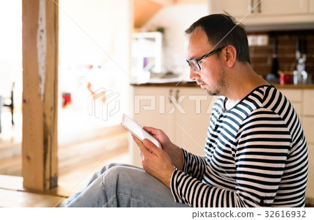 Young man in striped t-shirt with tablet at home. 32616932