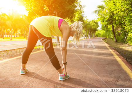 Fitness woman runner stretching before jogging Fitness woman runner stretching before jogging 32618073