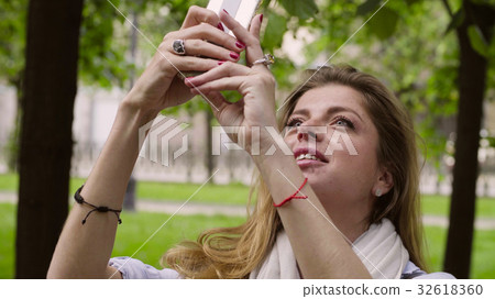 Portrait of young woman walking with smartphone 32618360