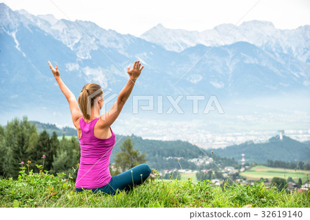 young woman meditate on top of the mountain 32619140