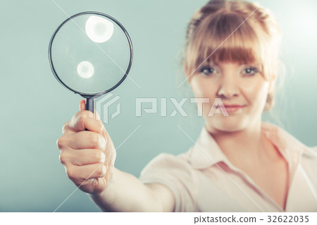 Woman holding magnifying glass Woman holding magnifying glass 32622035