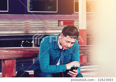 Handsome young asian man looking smart phone Handsome young asian man looking smart phone 32623003