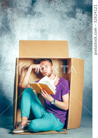Introvert concept. Man sitting inside box and Introvert concept. Man sitting inside box and 32624121