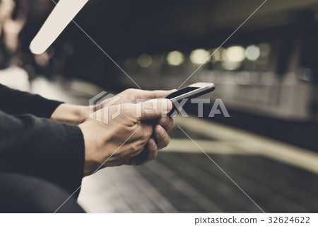 man using smartphone in underground station 32624622