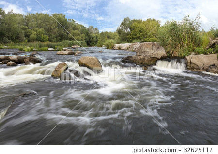 The rapid flow of the river, rocky coasts blue sky 32625112