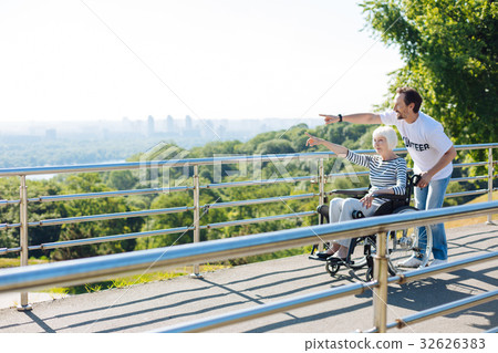 Kind bright man taking disabled lady for a walk Kind bright man taking disabled lady for a walk 32626383