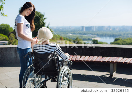 Devoted bright girl holding elderly lady by the Devoted bright girl holding elderly lady by the 32626525