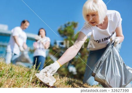 Active aged lady picking up litter in the park Active aged lady picking up litter in the park 32627390