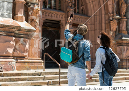 Youthful guy and lady taking picture while Youthful guy and lady taking picture while 32627795