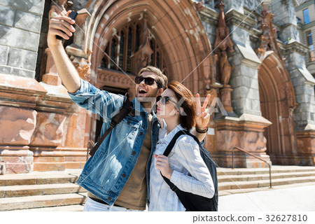 Cheery youthful couple using gadget while Cheery youthful couple using gadget while 32627810