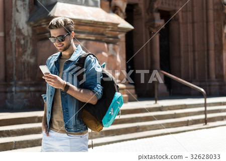 Happy youthful man with beard using gadget while Happy youthful man with beard using gadget while 32628033