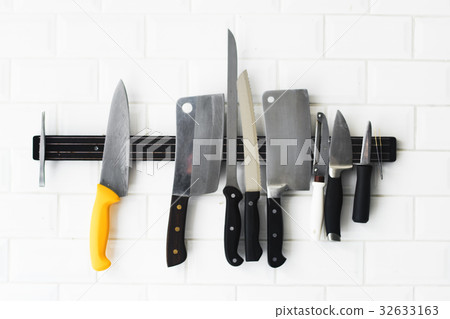 Set of knifes hanging on the white wall Set of knifes hanging on the white wall 32633163
