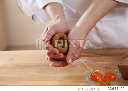 wrapping salted egg yolk with lotus paste wrapping salted egg yolk with lotus paste 32635431