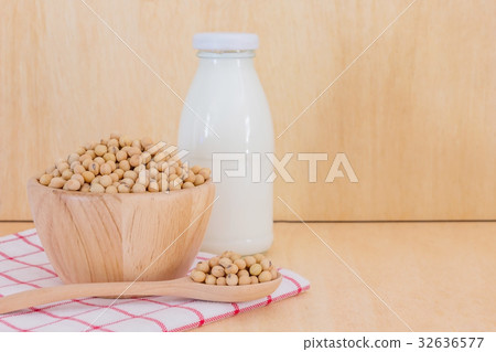 soy milk in glass bottle with soy beans in spoon 32636577