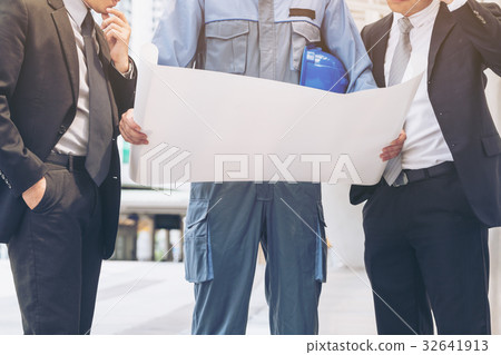 Engineer and business man discuss about blueprint 32641913