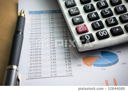 financial charts on the table with laptop, calculator, pen and g financial charts on the table with laptop, calculator, pen and g 32644080