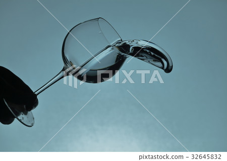 Water spilling from a wine glass 32645832