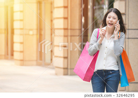 happy woman shopping talking on mobile phone happy woman shopping talking on mobile phone 32646295