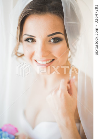 Luxury bride in white dress posing while preparing Luxury bride in white dress posing while preparing 32647293