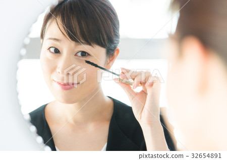 woman in suit applying makeup woman in suit applying makeup 32654891