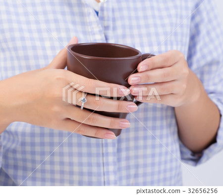 Female hands holding a brown cup 32656256