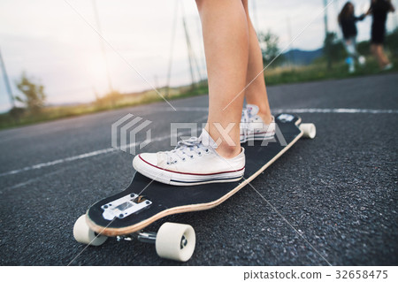 Unrecognizable teenage girl on skateboard outdoors 32658475