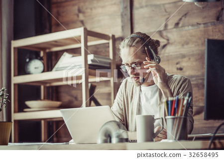 Freelancer at working process using headphones and Freelancer at working process using headphones and 32658495