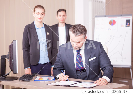 Adult businessman writing on folder with papper 32661983