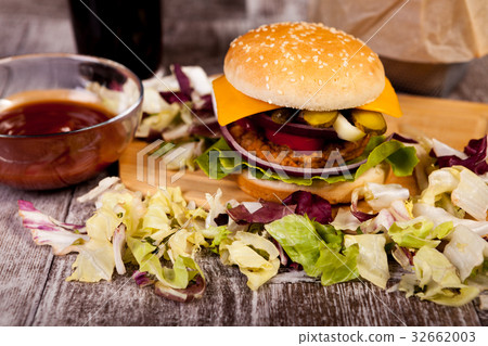 Delicious home made burgers on wooden plate next 32662003