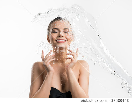 Pretty girl enjoying water splash studio shot 32680448