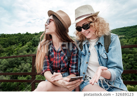Two girls using smartphone navigating system at 32689123