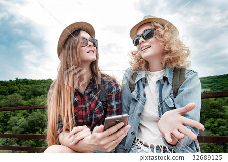 Two girls using smartphone navigating system at 32689125