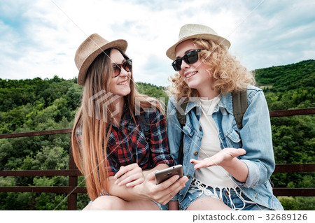 Two girls using smartphone navigating system at 32689126