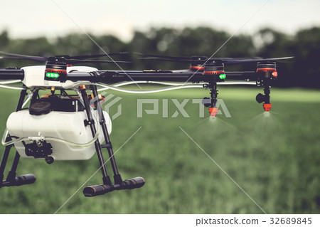 Closeup view of agriculture drone spraying water 32689845