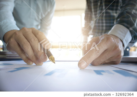 Two businessmen looking at report and having 32692364