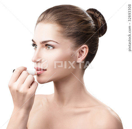 Beautiful woman applying hygienic lip balm. 32693308
